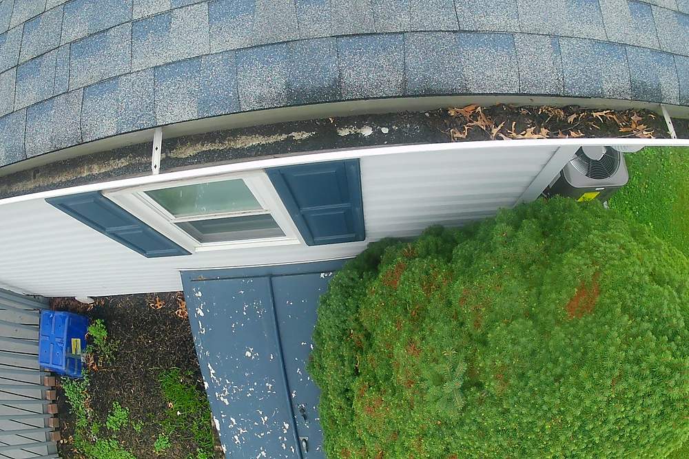 Leaves and debris built up at a downspout opening before gutter cleaning in Limerick, PA