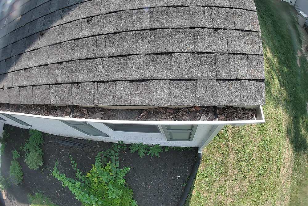 Gutter filled edge to edge with wet leaves before cleaning in King of Prussia, PA
